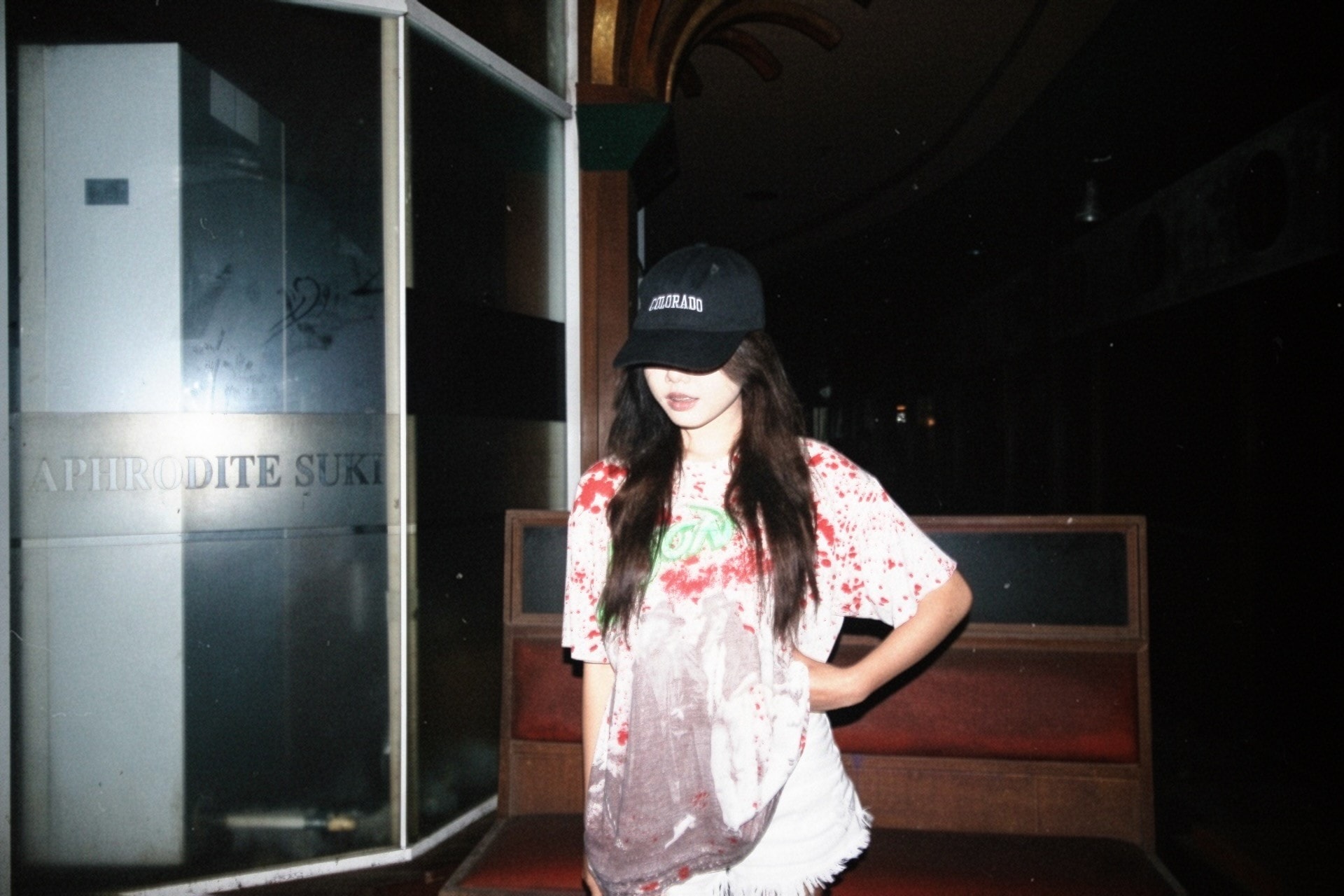 A paint-splattered vintage tee under a shopfront light