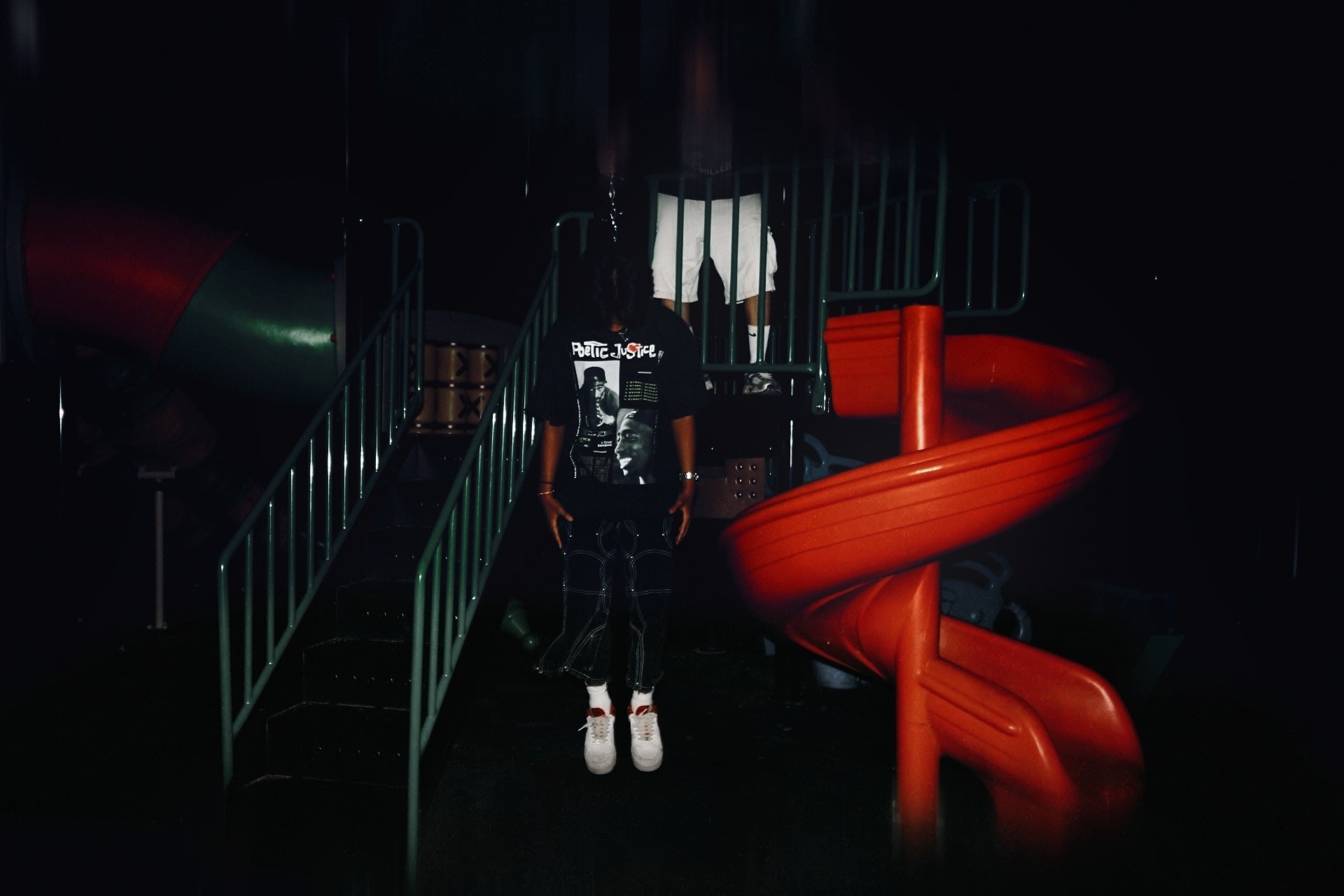 A Poetic Justice tee beside a red spiral slide