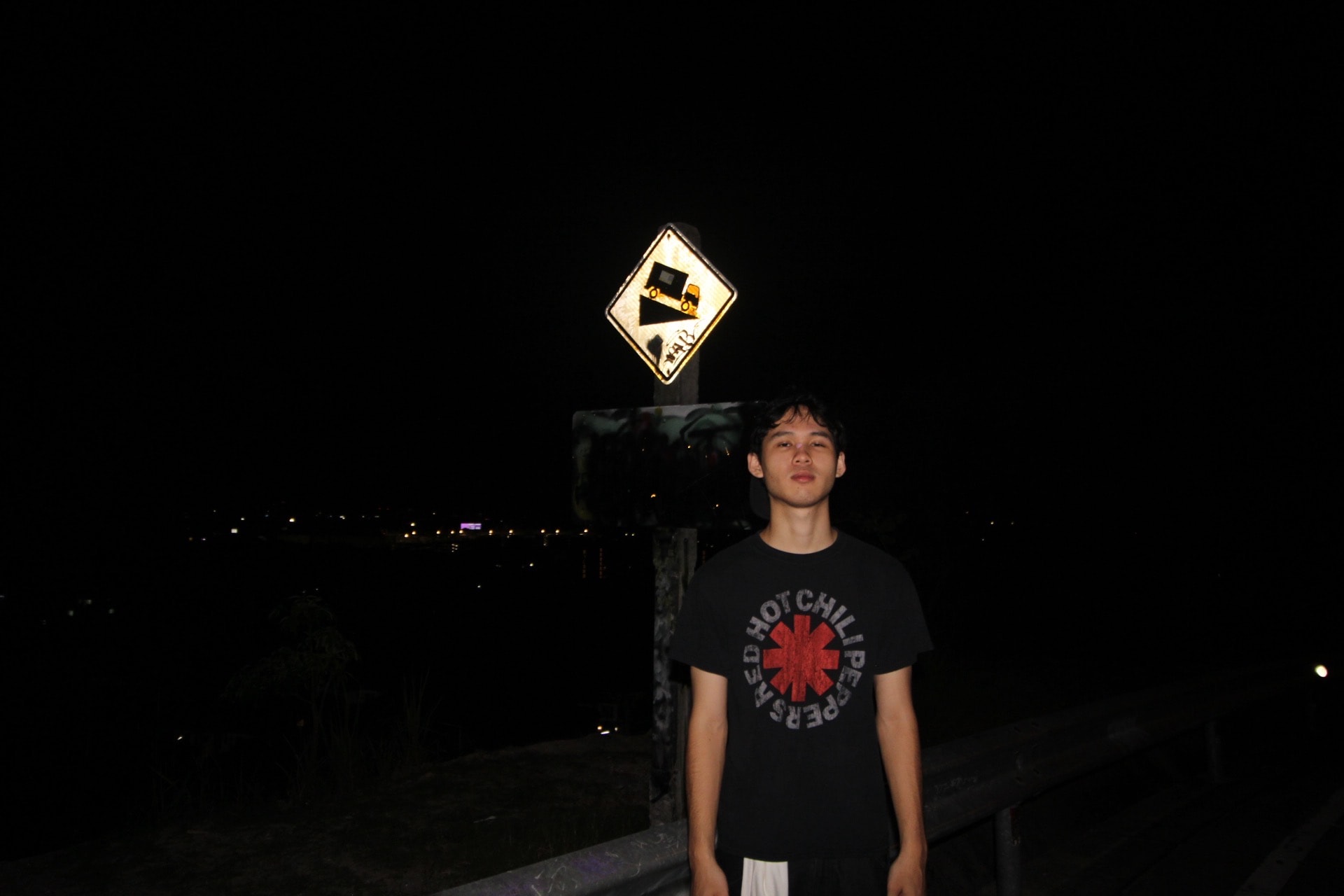 A Red Hot Chili Peppers tee on an empty road at night
